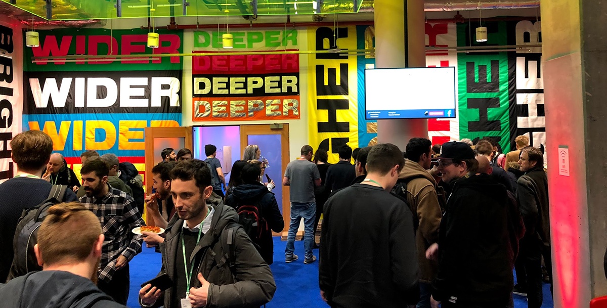 Groups of people having conversations in a colourful room.